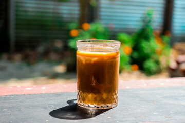 Iced Coffee Drink in Glass Jar on Weathered Table with Natural Background