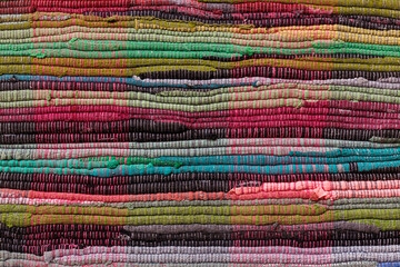 Obraz premium Colorful recycled fabric rugs, close-up of braided textile mats made from upcycled clothing yarn, vibrant home decor background