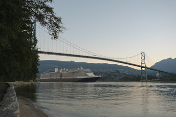 Modern classic cruiseship or cruise ship liner Nieuw Amsterdam arrival into Vancouver port, Canada during sunrise after cruise to Alaska with Stanley Park landscape