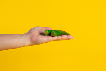 Fresh okra and hand isolated on yellow background