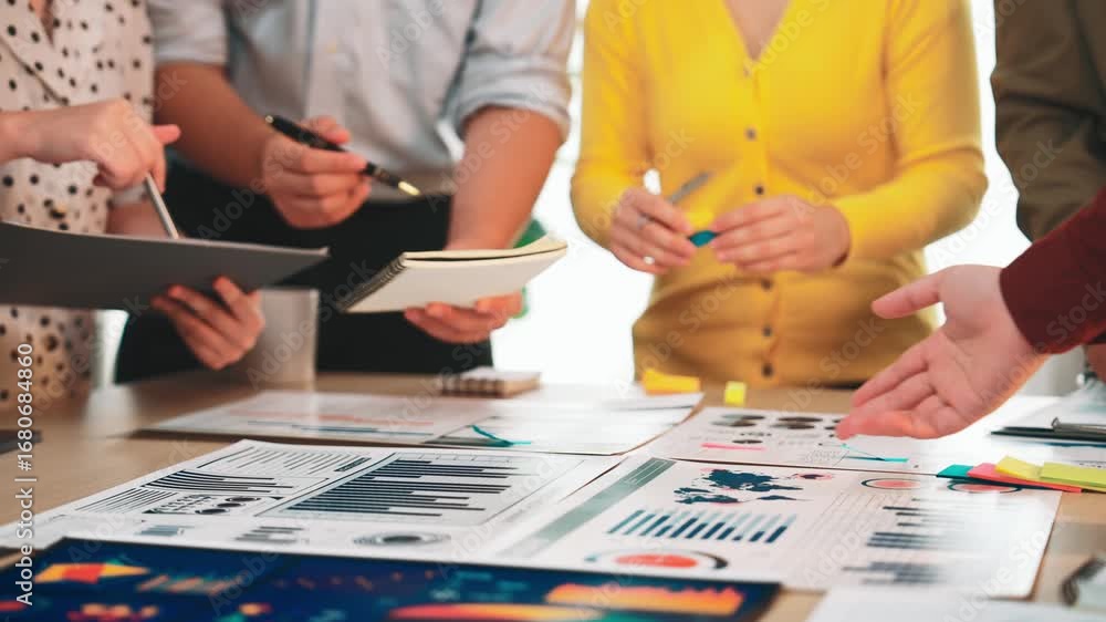 Aufkleber a dynamic team engages in discussion and data analysis in an office workshop, utilizing charts and d