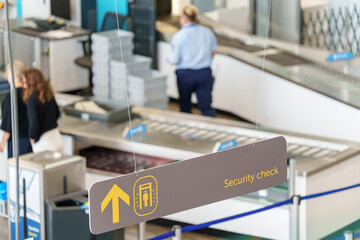Security check sign at airport guiding passengers to screening area