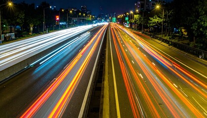 Night highway with vibrant light trails from speeding vehicles.