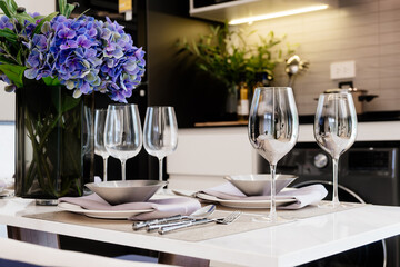 A set table with plates, place settings and glasses for dinner in a restaurant.