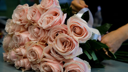 Female florist arranges delicate bouquet of pink alstroemeria flowers. Flower delivery. Small business concept