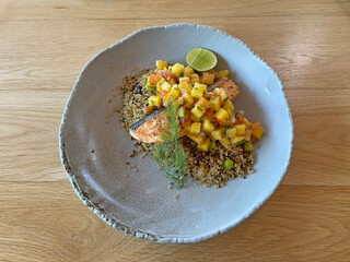Salmon steak served with fruit salad and grains 