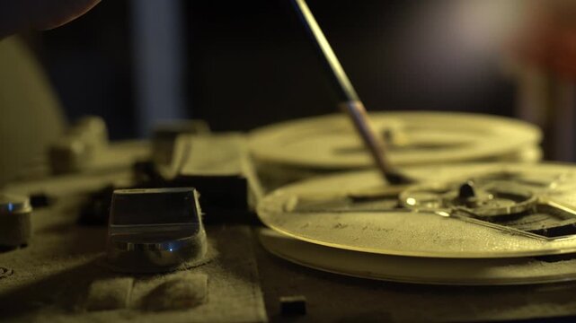 Restoring vintage tape recorder with pencil in hands