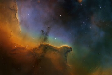 A vibrant nebula displays swirling gas and dust in shades of orange, blue, and green