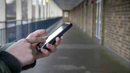 Close-up shot of children’s hands using smartphones in school corridor — exploring social media, games, and digital learning