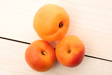 Organic ripe apricots on a wooden table, close-up, top view.