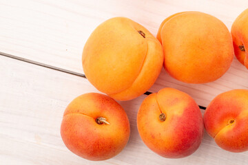 Organic ripe apricots on a wooden table, close-up, top view.