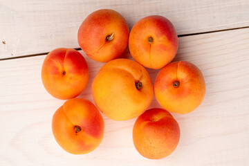 Organic ripe apricots on a wooden table, close-up, top view.