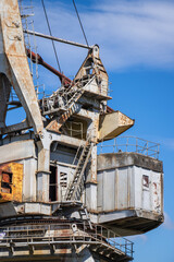 Large industrial crane against a clear blue sky at an operational construction site during the day
