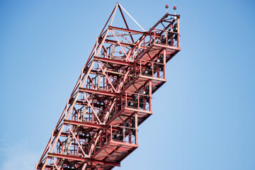 Construction crane towering against a clear blue sky in an urban environment during daytime