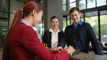 Customer making payment at hotel reception using credit card terminal