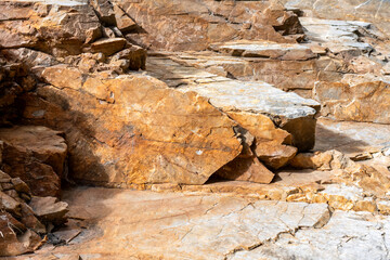 textured natural layers of stone in bright earthy tones. orange rock texture. abstract textured background with rugged rocky surface. natural