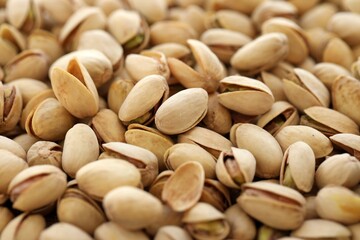 Tasty unpeeled pistachios as background, top view flat lay background