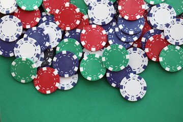 Casino gaming background with stacks of betting chips of different colors on green gaming mat