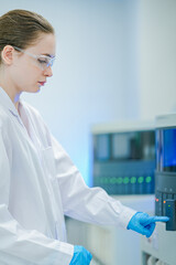 A focused clinical scientist initiates an automated analysis protocol, pressing the start button on a sophisticated immunohistochemistry (IHC) stainer to begin sample processing in the lab
