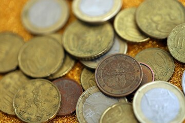 Big amount of euro coins on golden glitter background