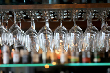 clean glass wine glasses hanging, background on the bar counter in the restaurant, abstract view of...