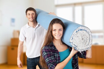 Couple holding carpet moving in new house