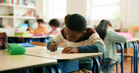 Education, students and boy writing in classroom for learning, fine motor skills or coordination....