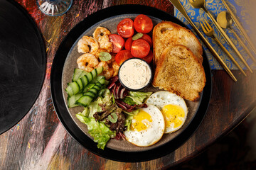 Breakfast plate with fried eggs, shrimp and vegetables