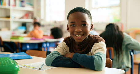 Boy, child and portrait in classroom with arms crossed, smile and confidence for learning at academy. Kid, happy learner and pupil for education, face or development with pride at elementary school