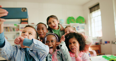 Education, funny face and selfie with children in class together for learning or memories. Development, growth and profile picture with group of excited kids in school classroom for social media