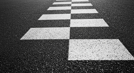 A close up shot of white stripes painted on a black asphalt road creating a pedestrian crosswalk pattern