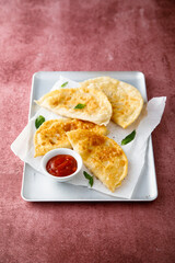 Deep-fried meat pies with tomato sauce