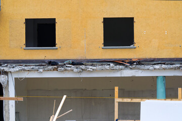 Close-up of yellow facade with missing windows of apartment building at deconstruction site at Swiss city of Zürich on a late summer day. Photo taken September 1st, 2025, Zurich, Switzerland.
