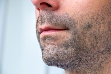 Obraz premium Close-up side profile man’s face with short stubble and early gray hairs, Facial hair detail, Natural beauty in aging, Signs maturity, highlighting facial texture and natural aging, neutral background