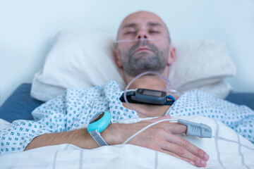 Young person, man with sleep apnea monitoring device and fingertip pulse oximeter, male patient...