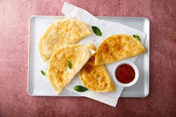 Deep-fried meat pies with tomato sauce