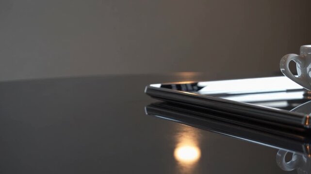 extended visual representation of financial transaction card placed alongside vacant beverage container made of ceramic situated within metallic serving platter