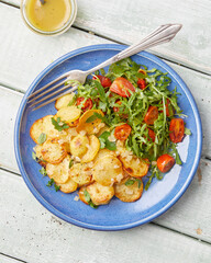 Herb roasted potatoes with arugula salad