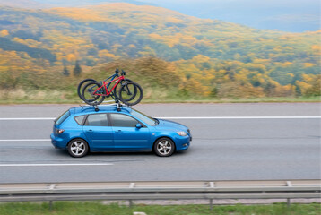 Fototapeta premium Old Japanese Hatchback On Intercity Highway With Bicycles On Roof