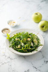 Arugula salad with green apple and almond flakes
