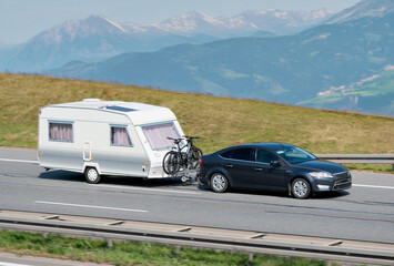 Naklejka premium Family Car With RV Van And Bicycles in Mountainous Scenic Landscape