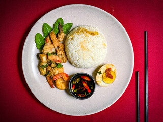 Stir-fried seafood with holy basil served over rice, a spicy and aromatic Thai street food dish packed with shrimp, squid, and fish.
