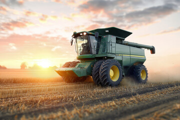 Fototapeta premium Farm harvester working in a field during a golden sunset