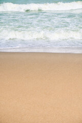 Closeup of waves sand beach and blue summer sea.