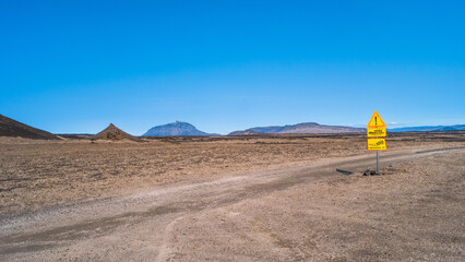 Panoramic view at Askja caldera hiking trail in the lifeless volcanic desert in Highlands, with stones and rocks thrown by volcanic eruptions, Iceland, summer, blue sky.