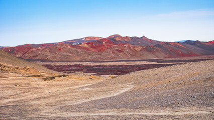 Panoramic view at Askja caldera hiking trail in the lifeless volcanic desert in Highlands, with stones and rocks thrown by volcanic eruptions, Iceland, summer, blue sky.