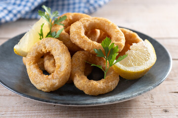 Crispy fried squid rings on wooden table