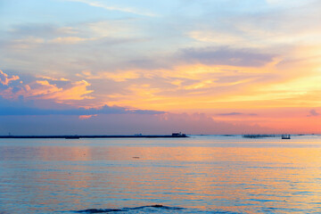 sunset in the sea. Beautiful colorful sky and cloud in twilight time background. Orange fluffy clouds and sun sunlight reflection in the blue sky.
