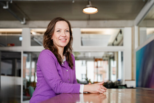 Confident professional at office desk smiling and looking at camera