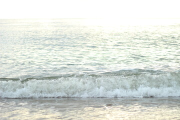 砂浜に打ち寄せる小さな波と静かな海